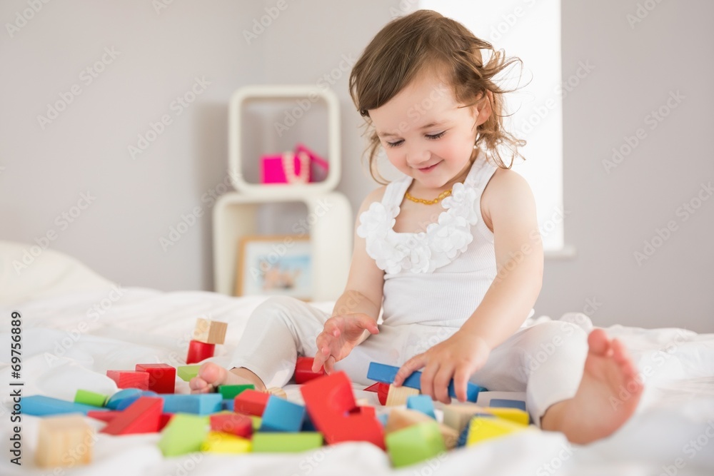 Cute girl playing with building blocks on bed Cute girl playing with building blocks on bed