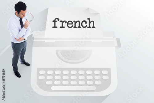 The word french and unsmiling businessman holding glasses © WavebreakMediaMicro