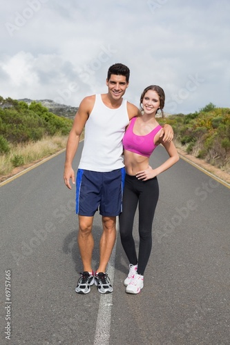 Portrait of a fit couple standing on road