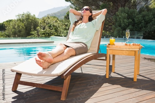 Woman relaxing by pool with breakfast on table © WavebreakmediaMicro