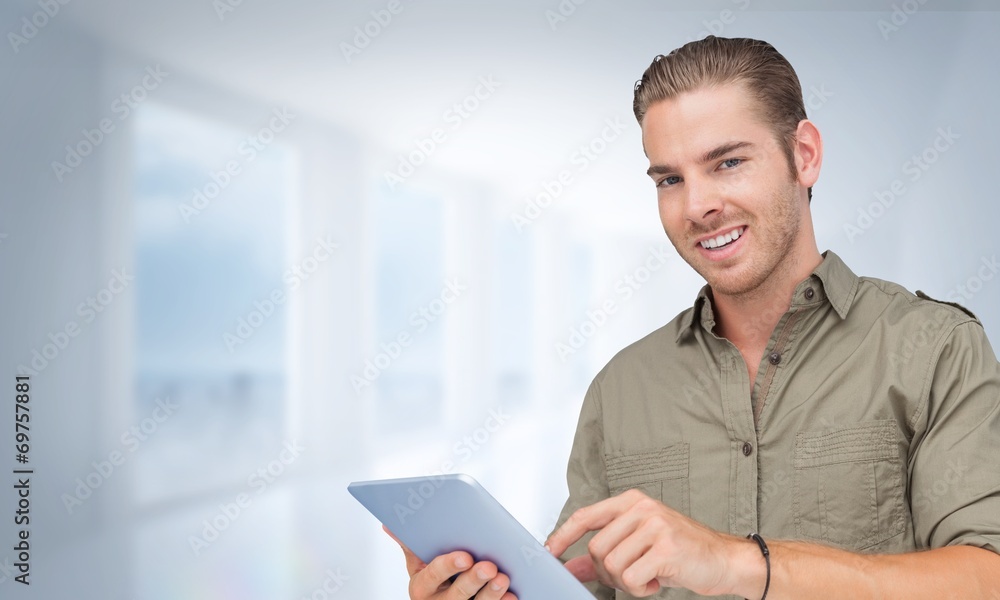 Composite image of happy man using tablet pc Composite image of happy man using tablet pc