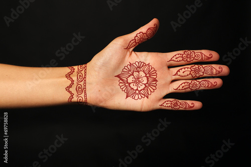 hand with mehendi on black background