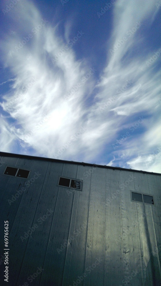 Industrial building metal wall and cloudy sky