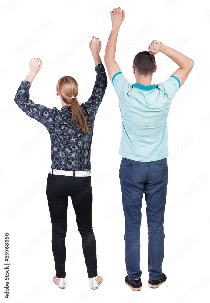 Back view of joyful couple celebrating victory hands up. Back view of joyful couple celebrating victory hands up.