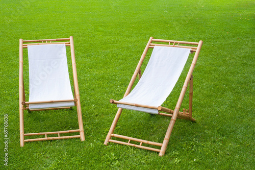 Obraz na plátně two folding chairs in a green park