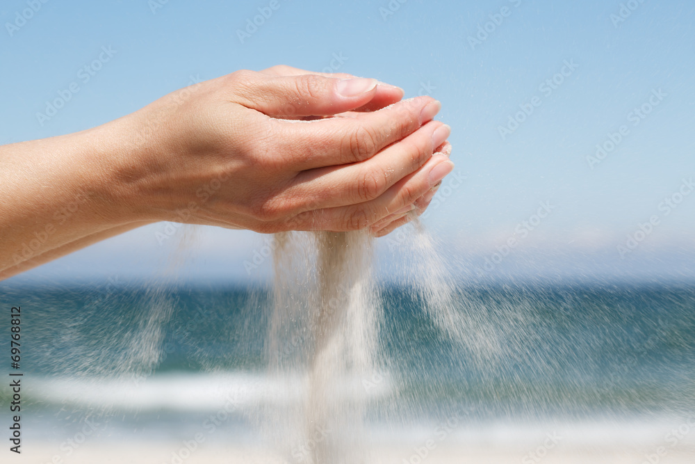 Female hands and sand