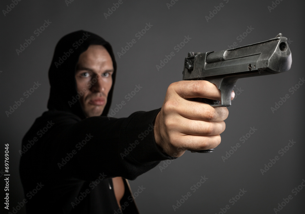 man shooting gun isolated on gray background. focus on gun man shooting gun isolated on gray background. focus on gun