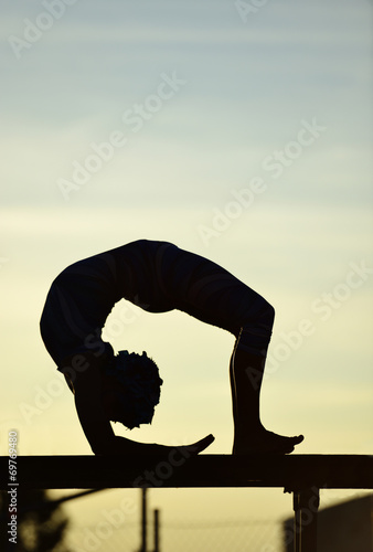 women contortionist practicing gymnastic yoga in silhouette