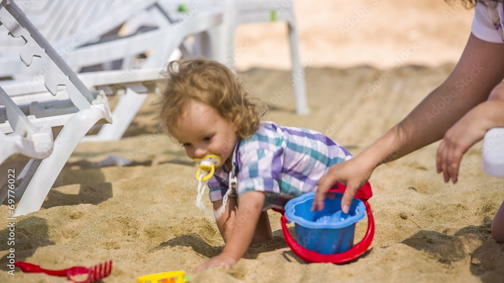 Mother and Baby playing with toys on the beach Mother and Baby playing with toys on the beach
