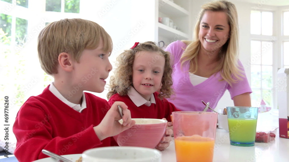 Mother And Children Having Breakfast In Kitchen Together Mother And Children Having Breakfast In Kitchen Together