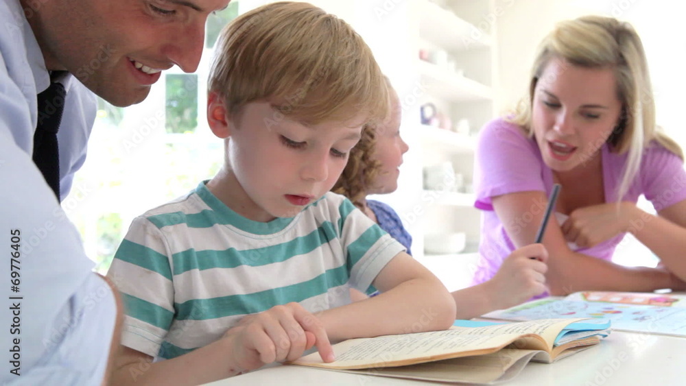 Parents Helping Children With Homework In Kitchen Parents Helping Children With Homework In Kitchen