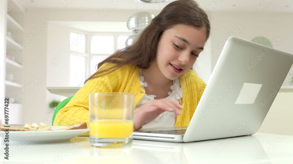 Hispanic Girl Using Laptop Eating Breakfast Hispanic Girl Using Laptop Eating Breakfast