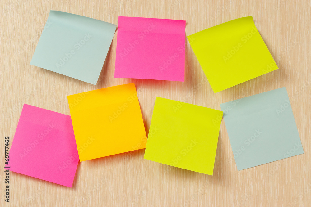Colorful stickers on a wooden board from notice Colorful stickers on a wooden board from notice