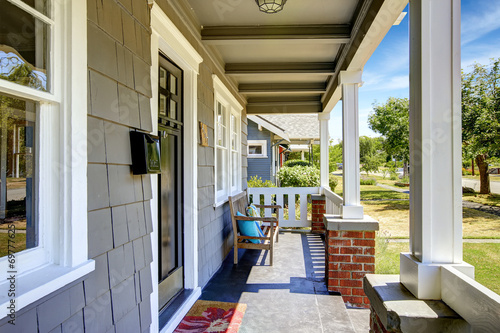 Large entance porch with brick trim and white railings