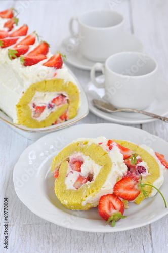 Swiss roll with cream and strawberries, selective focus