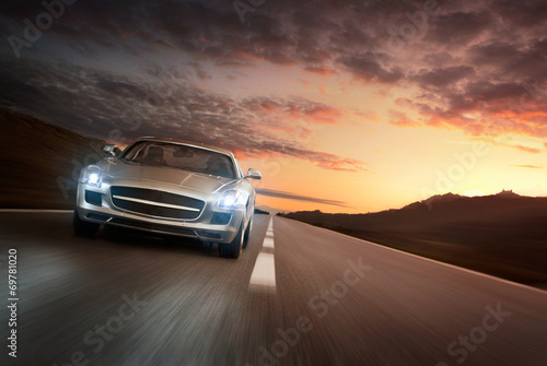 Luxury sports car speeding on empty highway at the sunset © rangizzz