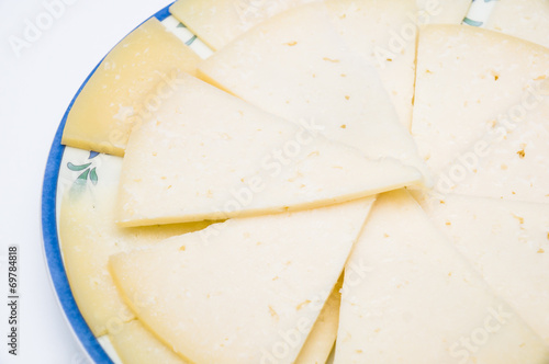 plate with slices of spanish manchego cheese