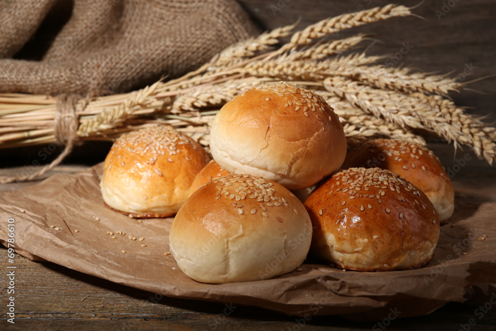 Tasty buns with sesame on wooden background Tasty buns with sesame on wooden background