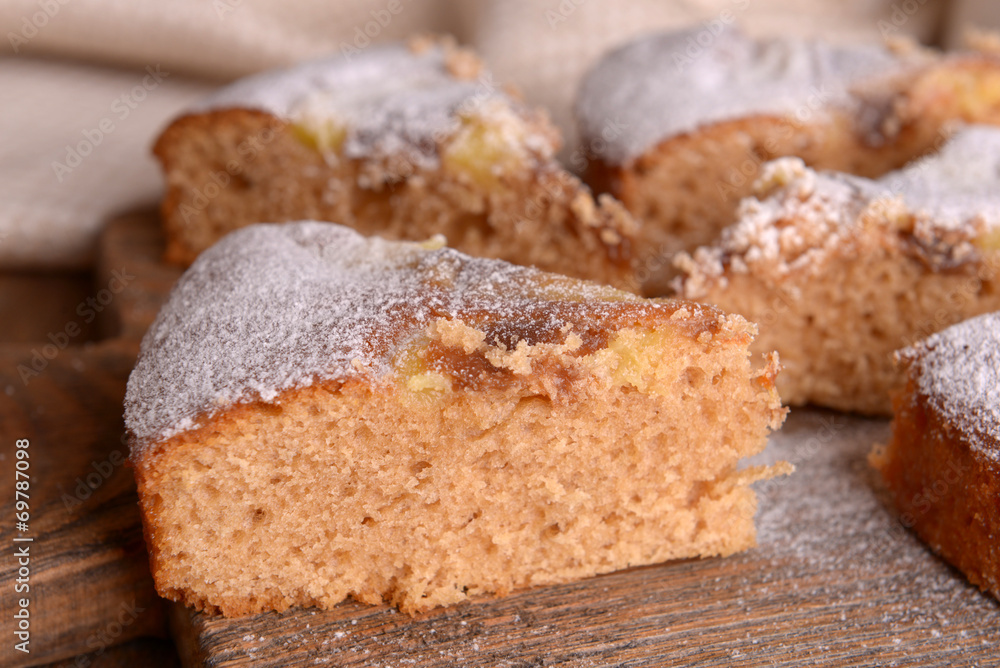 Pieces of delicious cake on cutting board on wooden table Pieces of delicious cake on cutting board on wooden table
