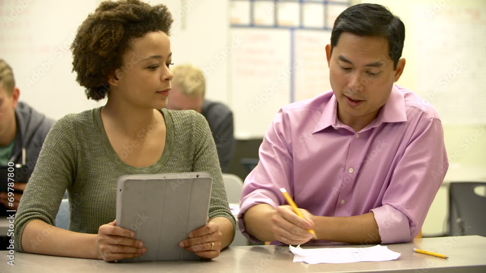 Female High School Student With Teacher Using Digital Tablet Female High School Student With Teacher Using Digital Tablet