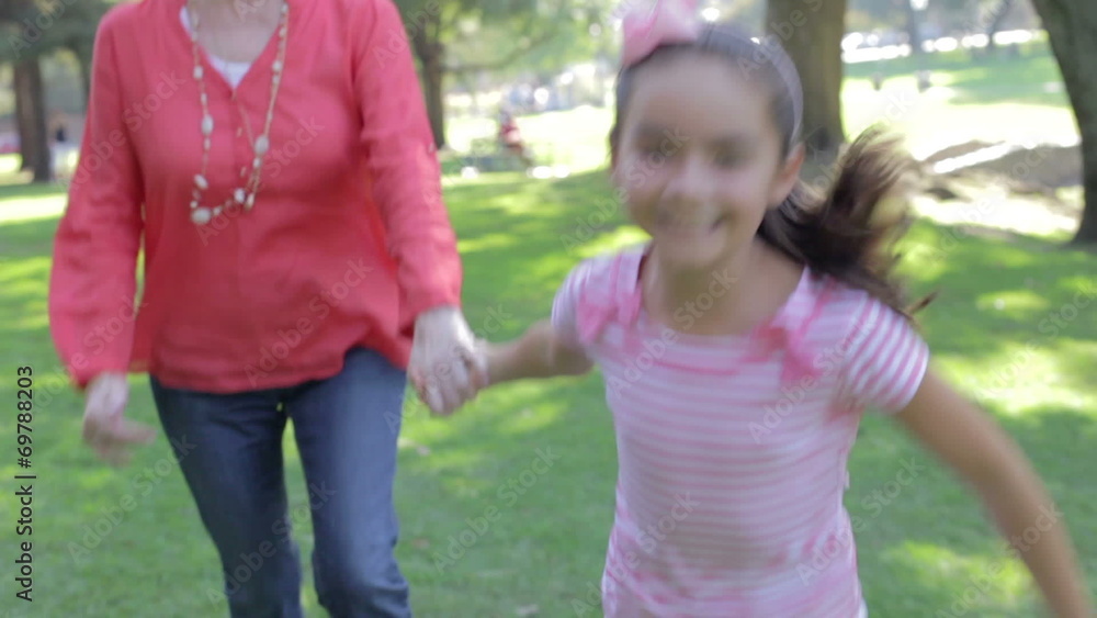 Grandmother And Granddaughter Running Through Park Together Grandmother And Granddaughter Running Through Park Together