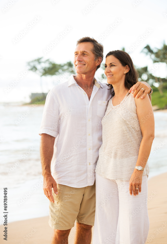 Obraz premium Mature Couple Enjoying Sunset on the Beach