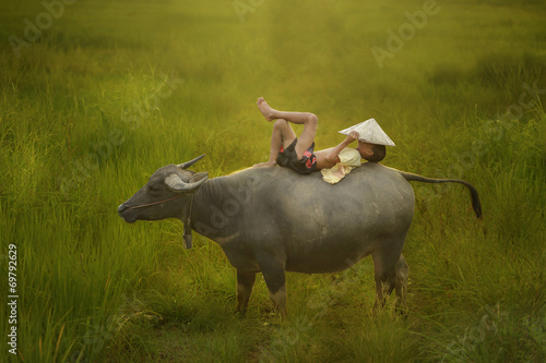 Fotografía Happy boy riding water buffalo.