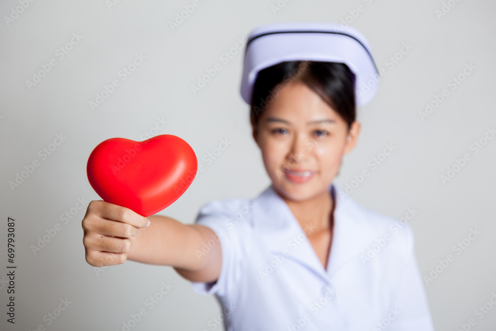 Young Asian nurse show red heart focus at the heart Young Asian nurse show red heart focus at the heart