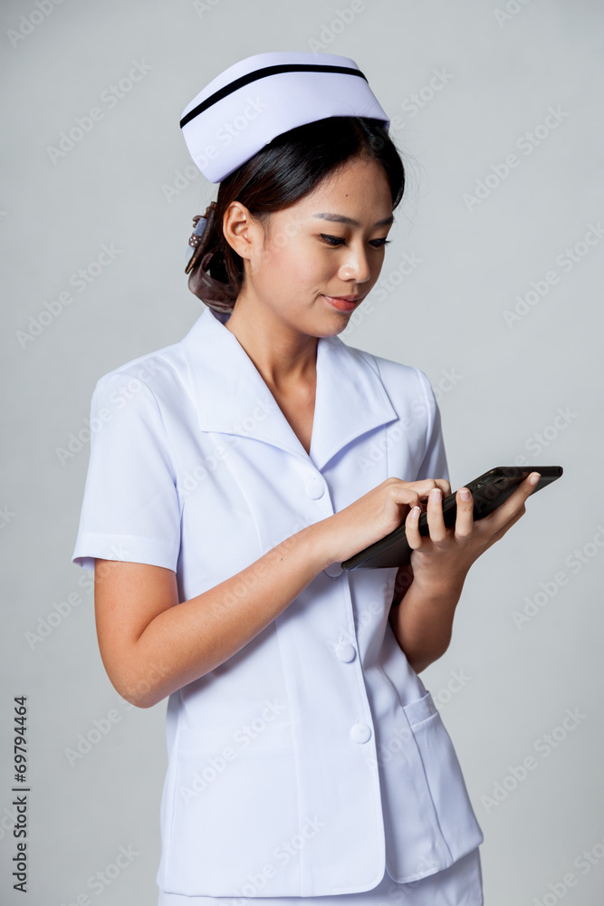 Young Asian nurse touch a tablet pc screen Young Asian nurse touch a tablet pc screen