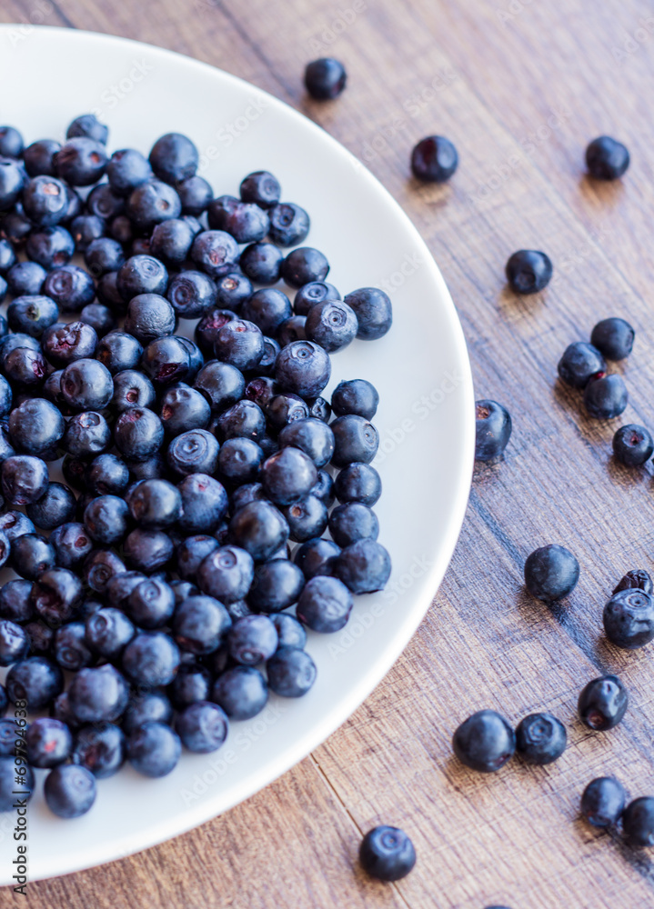 blueberries on a white plate, vertically blueberries on a white plate, vertically