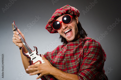 Funny scotsman playing red guitar photo