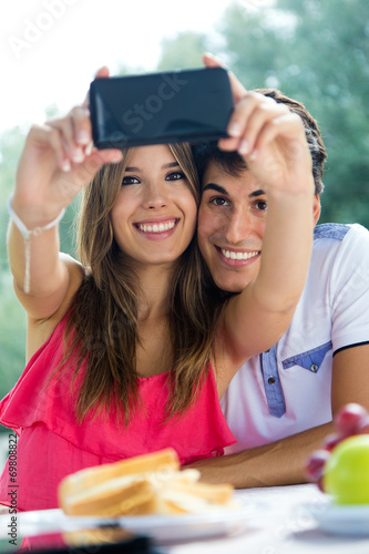 Couple taking photo of themselves with smart phone on romantic p