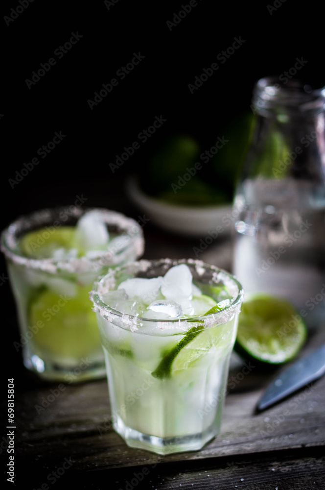 Water with ice and limes on rustic background Water with ice and limes on rustic background