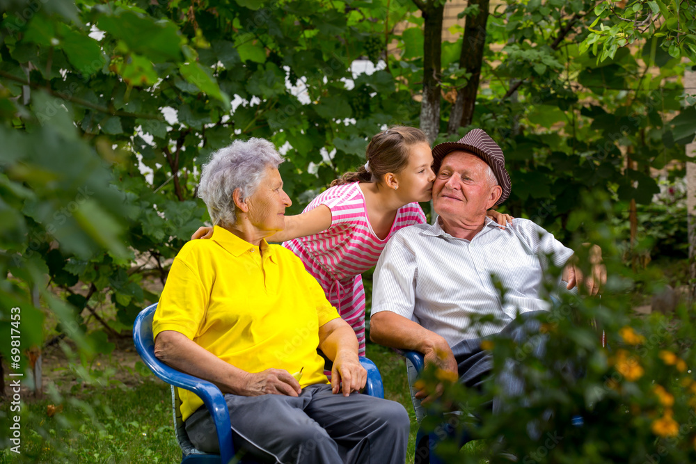 Grandparents and granddaughter sitting outside Grandparents and granddaughter sitting outside