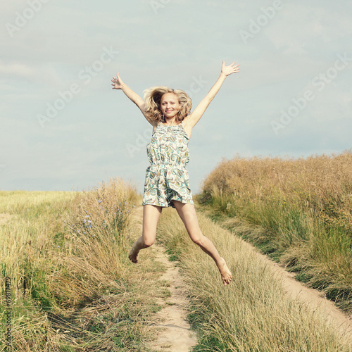 Happy Young Woman Jumping over blue sky. 