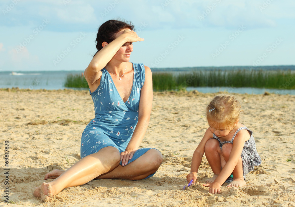 Mother with children playing with sand on beach Mother with children playing with sand on beach