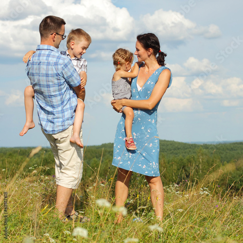 Family of four standing on a mountain 
