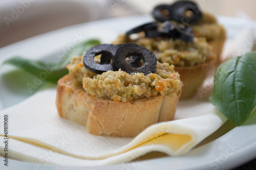 Bread slice with olive cream and black olives on top