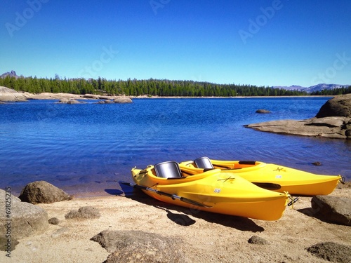 Two yellow kayaks on the shore of a beautiful Mountain Lake.