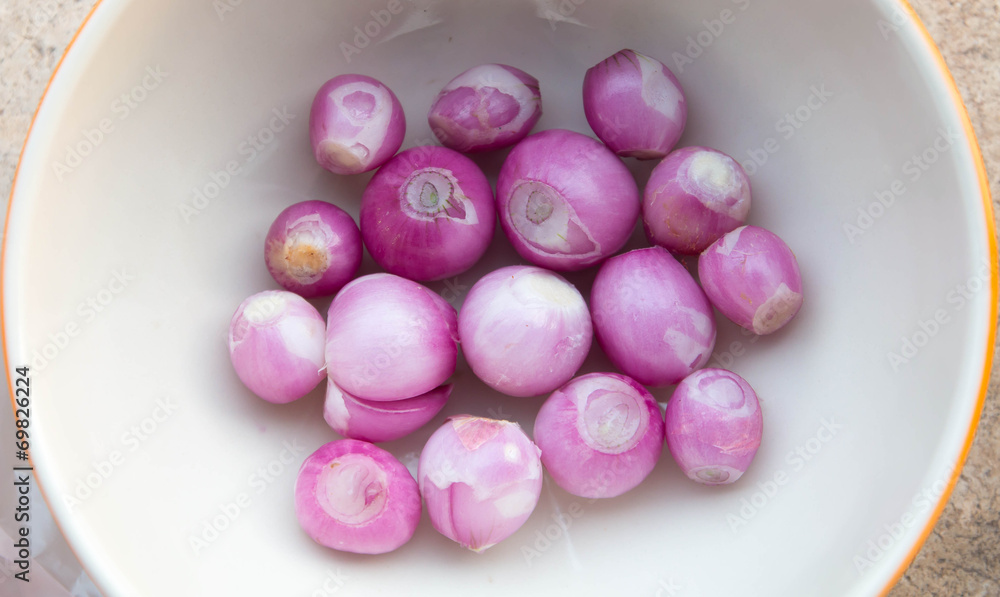 Sliced shallot with whole shallots on a cutting board Sliced shallot with whole shallots on a cutting board