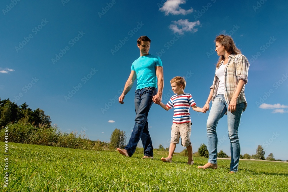 Happy young family with their child walking outdoors Happy young family with their child walking outdoors