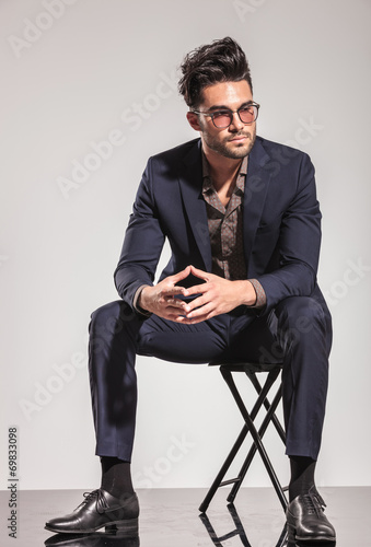fashion man in suit sitting and looks to  side