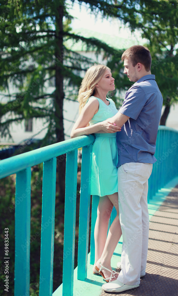 Pretty couple in love on the bridge in the park Pretty couple in love on the bridge in the park