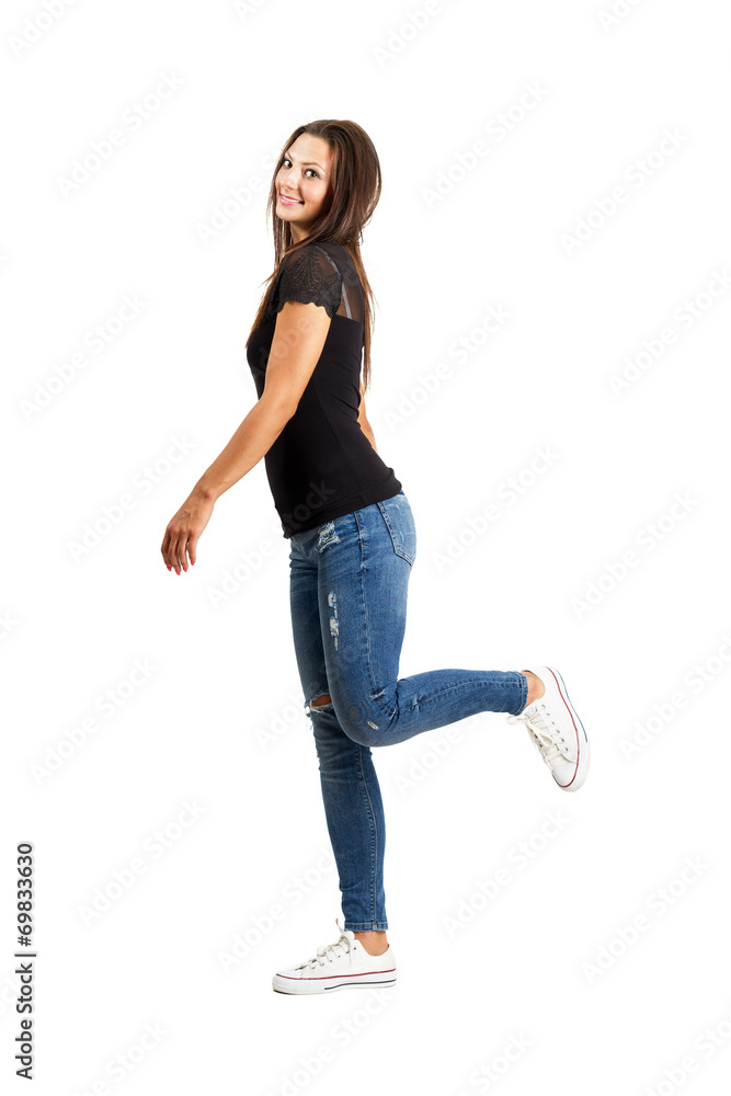Portrait of a smiling woman posing on tiptoes, isolated on gray background  Royalty-Free Stock Image - Storyblocks