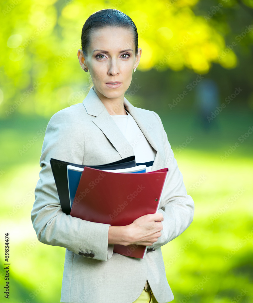 Fototapeta premium Portrait of smiling business woman with paper folder. Student