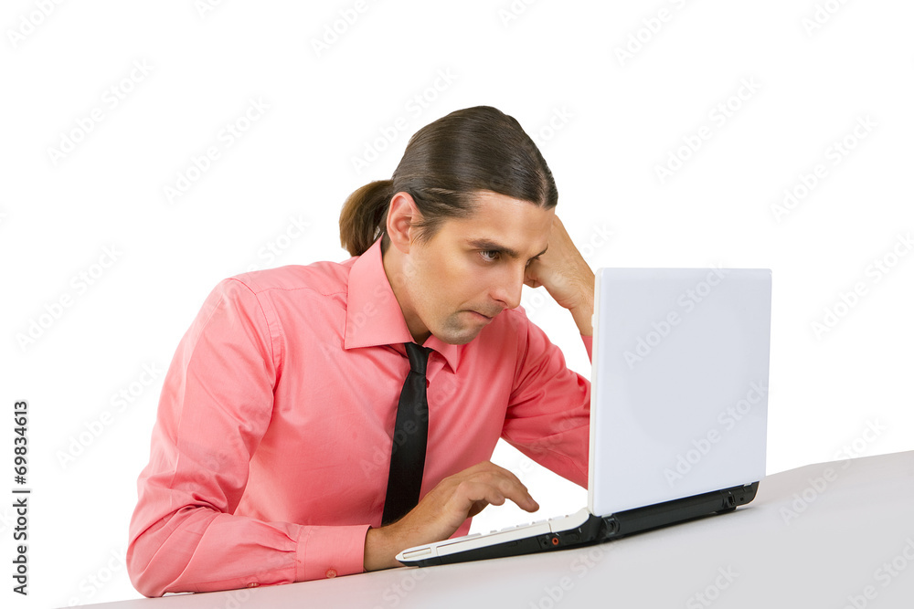 Angry grumpy Young man with laptop looking at the monitor over w Angry grumpy Young man with laptop looking at the monitor over w