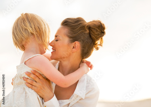 Portrait of mother and baby girl hugging on the beach 