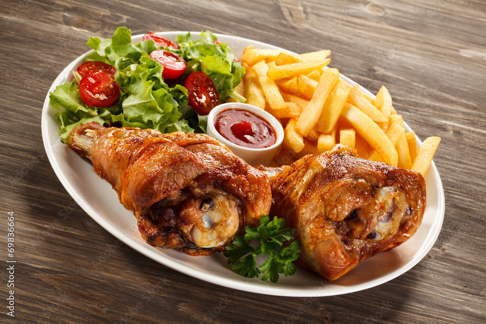 Grilled turkey legs with French fries and vegetables Grilled turkey legs with French fries and vegetables