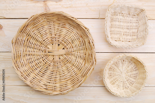 Rattan plate or basket on wooden table and tablecloth on table w