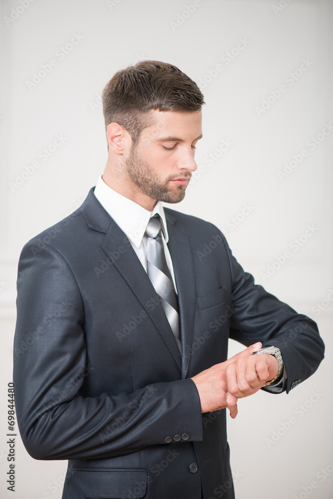 Portrait of handsome confident businessman standing and touching Portrait of handsome confident businessman standing and touching